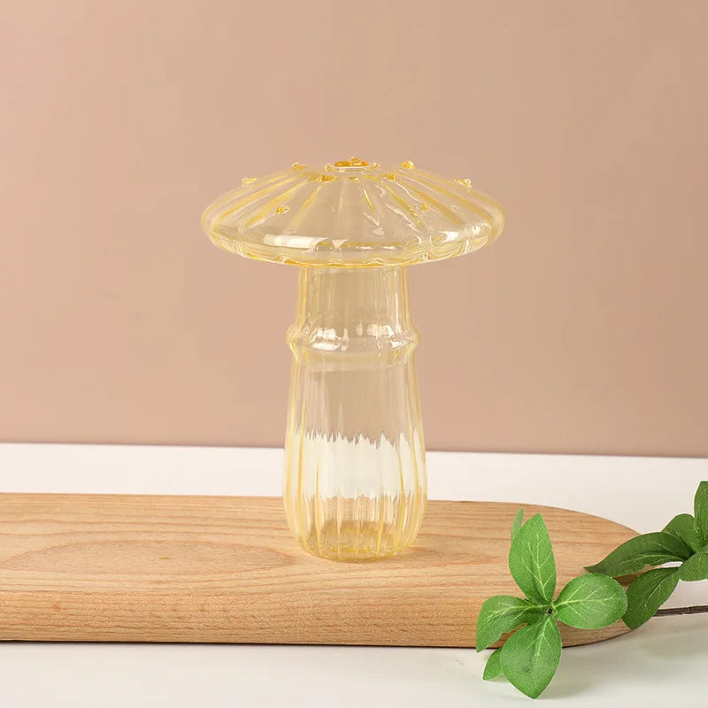 Clear glass vase with gold rim on a wooden board against a beige background