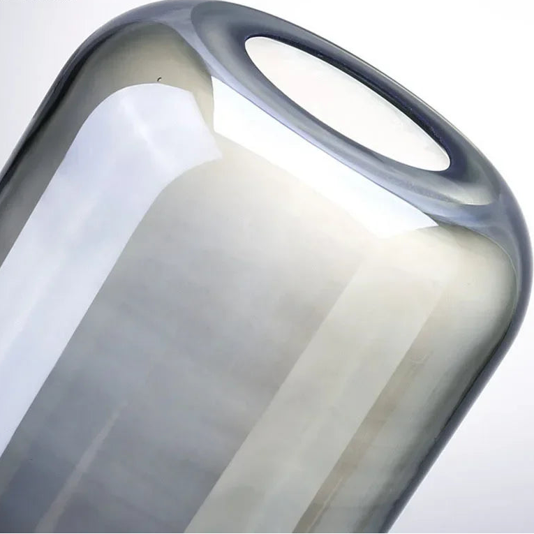 Close-up of a modern glass vase with a smooth, curved design on a white background.