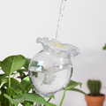 Water being poured into glass watering globe